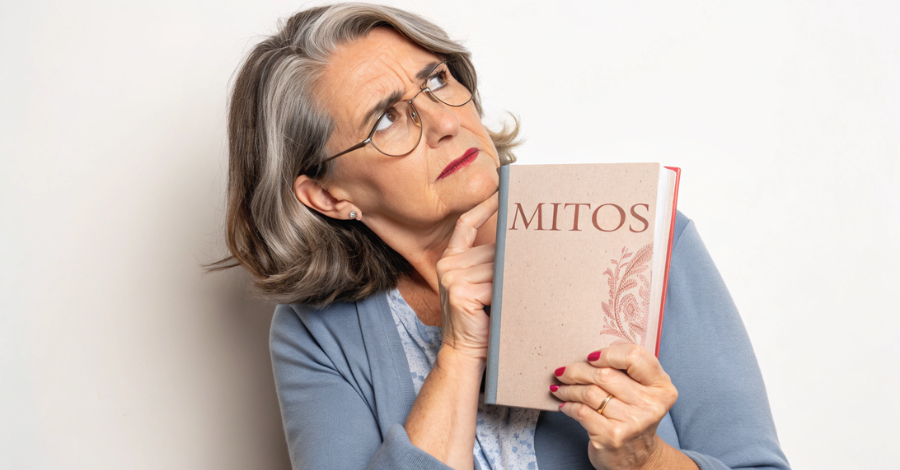 Mulher madura com uma expressão de ceticismo segurando um livro sobre mitos, simbolizando a desmistificação de informações erradas sobre nutrição na menopausa.